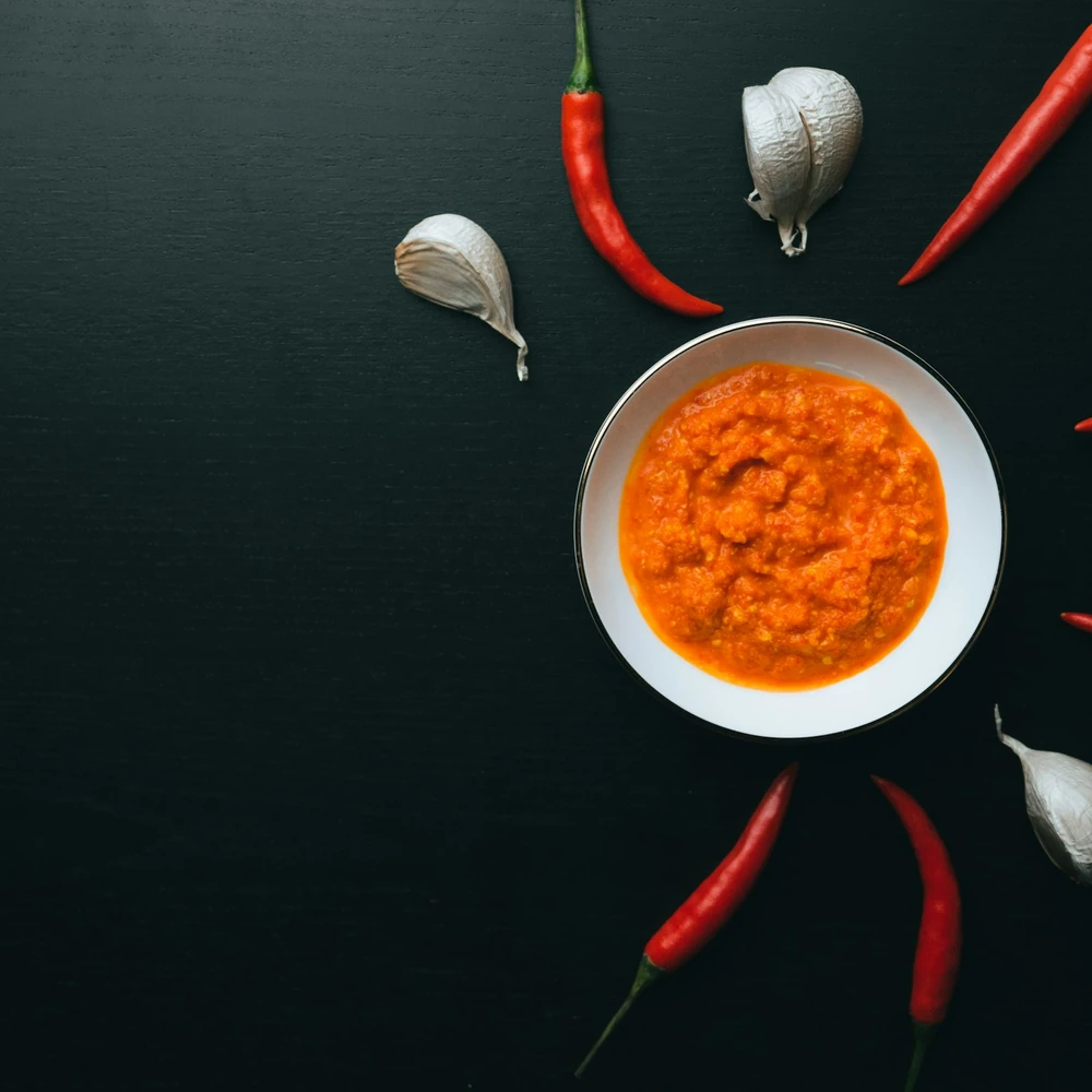 Mangkuk sambal dengan cabai dan bawang; foto stok