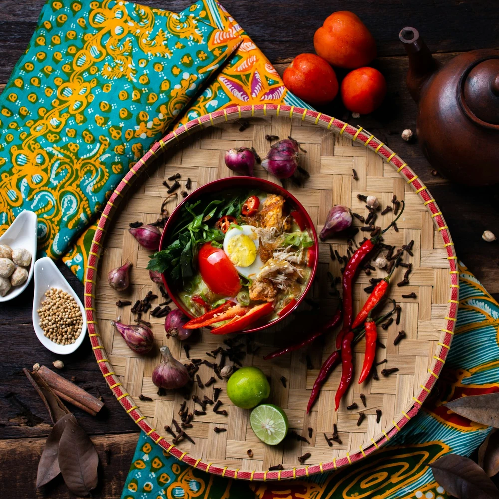Hidangan berbumbu di atas kain batik; foto stok